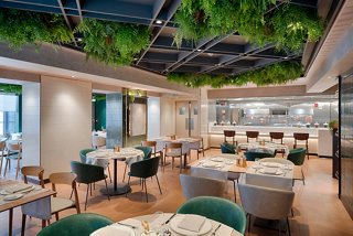 Ein warmes und einladendes Esszimmer mit eleganten Tischen und Pflanzen, perfekt für ein köstliches Essen | MSC Cruises