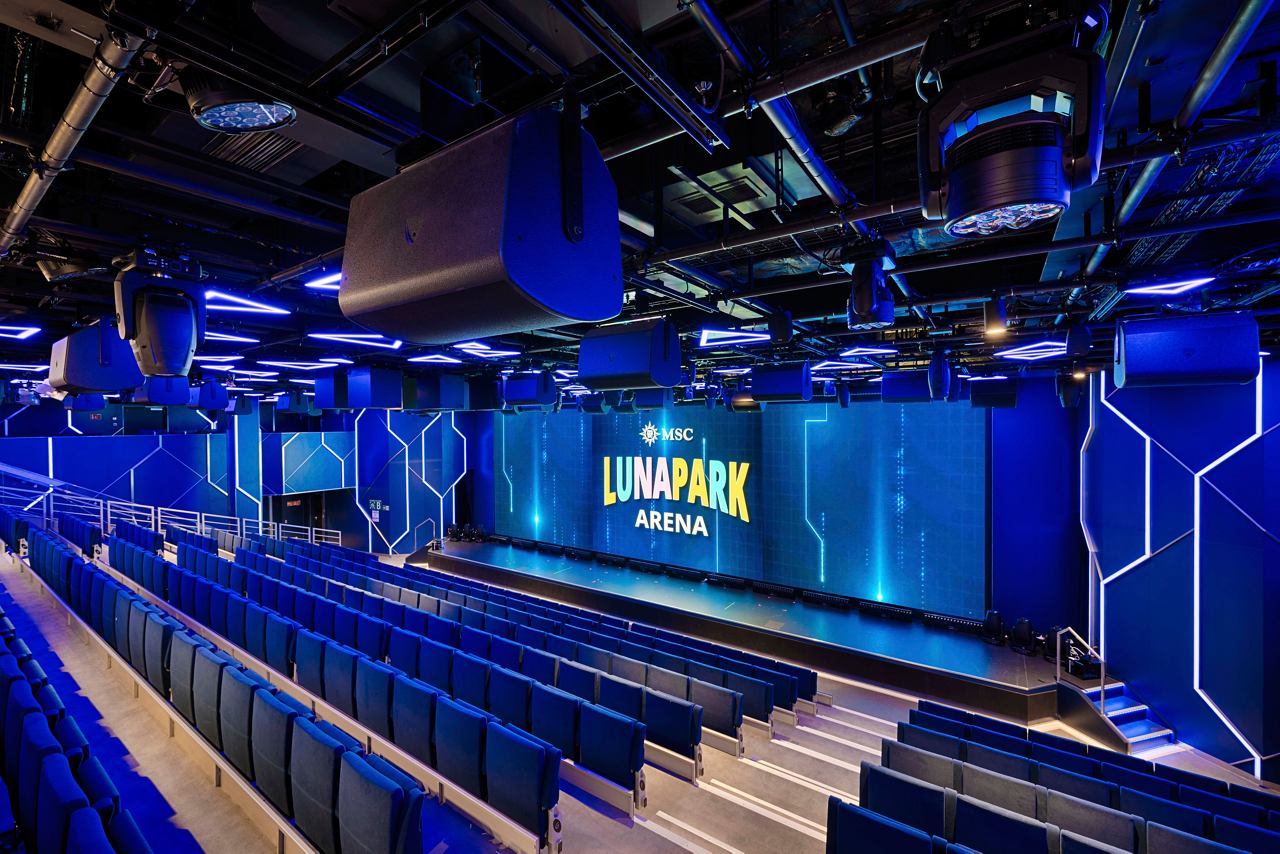A lively entertainment area featuring seating and vibrant blue decor at the MSC Luna Park Arena | MSC Cruises