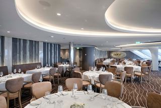 A stylish dining area in the MSC Yacht Club with elegant tables and comfortable chairs for guests to enjoy their meals | MSC Cruises