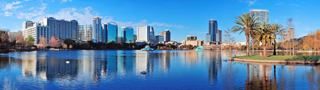Vue panoramique du parc Lake Eola à Orlando, avec des gratte-ciel et un ciel bleu reflété dans l'eau | MSC Croisières