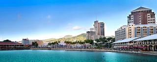 Une vue panoramique de la côte vibrante de Port Louis, montrant la mer et les palmiers sous un ciel bleu clair | MSC Cruises