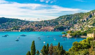 A stunning coastal view of Villefranche in France with boats on the Mediterranean Sea and lush green hills | MSC Cruises