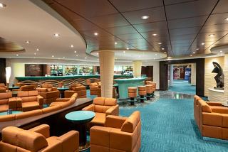 A stylish lounge area featuring comfortable seating and a bar, inviting relaxation and socialising on the MSC Fantasia | MSC Cruises