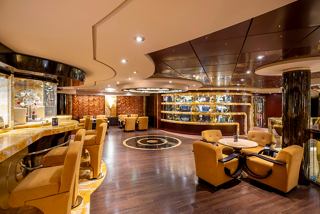 A warm and inviting lounge area with comfortable seating and tables for relaxation | MSC Cruises