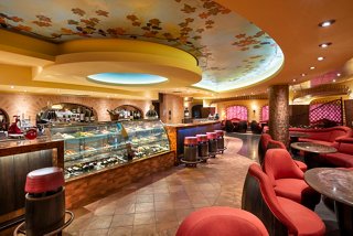 A vibrant bar area with comfortable seating and a display of food and drinks, inviting guests to relax and enjoy | MSC Cruises