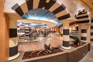 A welcoming lounge area with seating, a fountain, and decorative arches, perfect for relaxation on MSC Fantasia | MSC Cruises