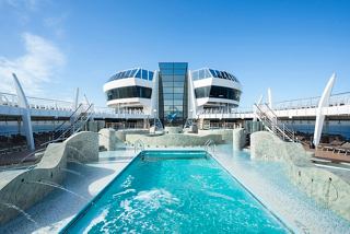 Una refrescante zona de piscina en el MSC Fantasia con tumbonas, invitando a los huéspedes a relajarse bajo un cielo despejado | MSC Cruceros