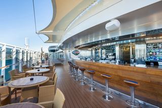 An inviting outdoor bar area on MSC Fantasia, featuring a spacious counter and comfortable seating for guests | MSC Cruises