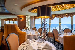 Elegant dining area in Il Cerchio D'Oro restaurant with sea views, beautifully set tables and warm decor | MSC Cruises