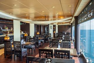 A warm and inviting dining area aboard MSC Fantasia with sea views and comfortable seating | MSC Cruises