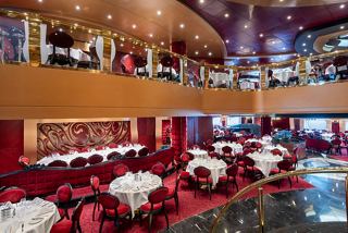 A stylish restaurant with red velvet chairs and tables, featuring an inviting atmosphere for dining on MSC Fantasia | MSC Cruises
