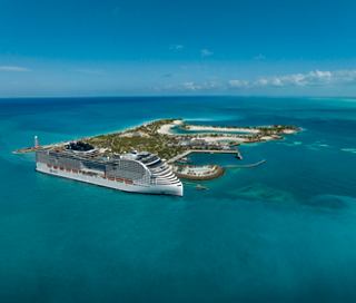 Aerial view of MSC World America docked at Ocean Cay, showcasing sandy beaches and lush vegetation | MSC Cruises
