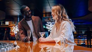 A couple enjoys cocktails together at the Golden Jazz Bar on MSC Divina, celebrating life onboard in a warm atmosphere | MSC Cruises