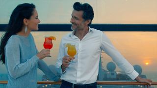 A couple enjoying colourful cocktails on deck during a beautiful sunset at sea | MSC Cruises