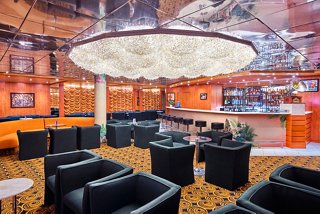 A stylish lounge area with comfortable seating and a large chandelier, inviting relaxation and socialising | MSC Cruises