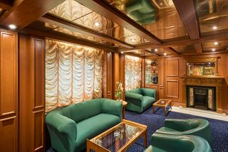 A stylish seating area featuring green sofas and armchairs, perfect for relaxation and socialising on the MSC Armonia | MSC Cruises
