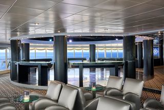 Cozy sitting area with armchairs and sofas in Starlight Disco on MSC Armonia overlooking the sea | MSC Cruises
