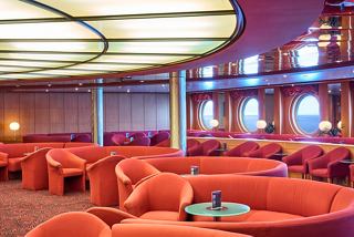 A vibrant sitting area featuring plush seating and a warm atmosphere for relaxation on MSC Armonia | MSC Cruises