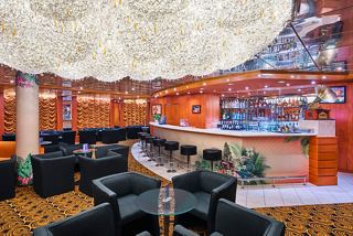 A stylish lounge area featuring comfortable seating and a vibrant bar counter, perfect for socialising | MSC Cruises
