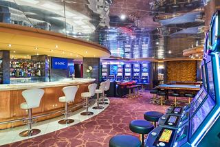Lounge area with bar and slot machines in Palm Beach Casino on MSC Armonia | MSC Cruises