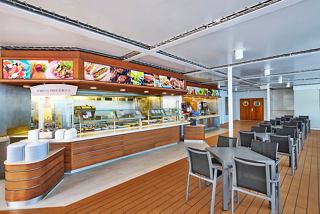 A welcoming dining area with a grill, tables, and chairs, perfect for enjoying meals on MSC Armonia | MSC Cruises