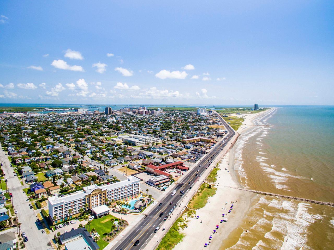 Aerial view of Galveston showcasing the sea, beach, and coastal buildings under a clear sky | MSC Cruises