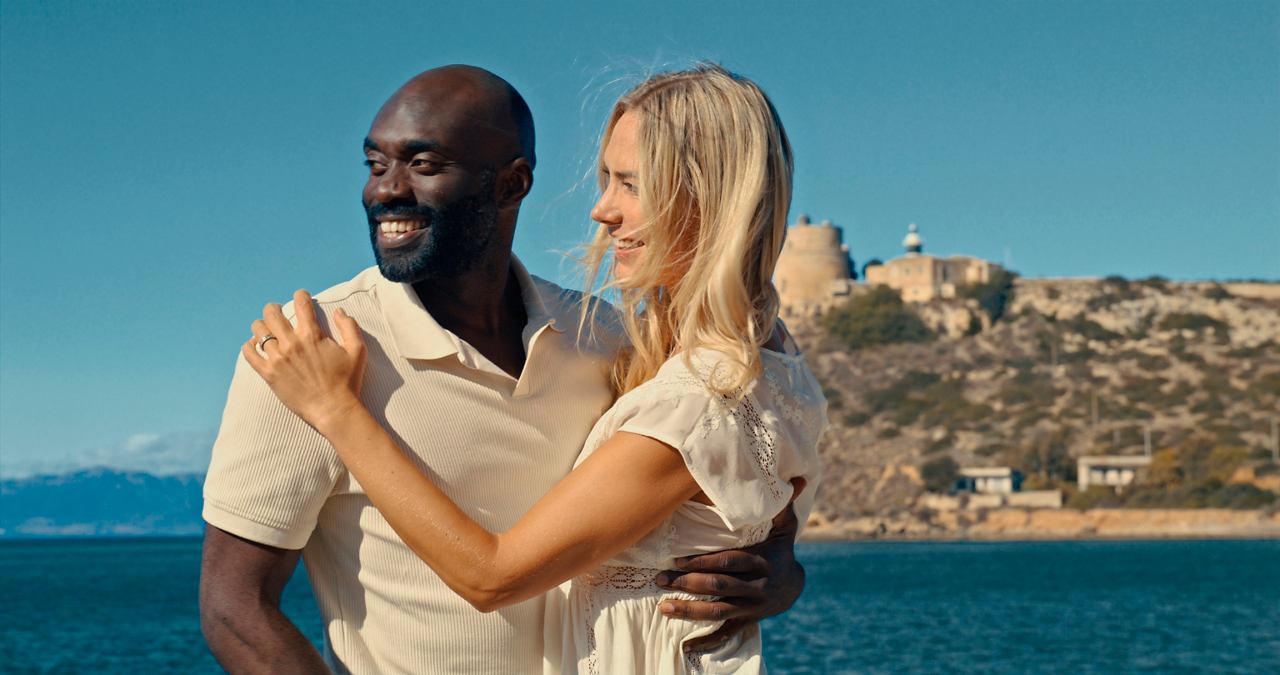 A joyful couple embraces by the sea with mountains in the background, enjoying a beautiful day in Cagliari | MSC Croisières