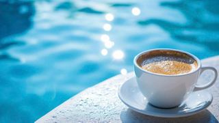 A cup of coffee sits on the edge of a pool, inviting relaxation and enjoyment in a serene setting | MSC Cruises