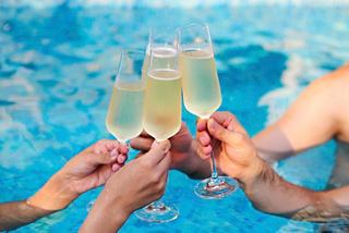 Cheers with glasses of champagne by the pool, celebrating together in a joyful moment | MSC Cruises