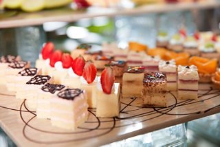 A tempting display of mini cakes and pastries topped with strawberries on a buffet table | MSC Cruises