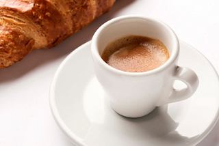 A warm cup of coffee beside a delicious croissant, perfect for a delightful breakfast experience | MSC Cruises