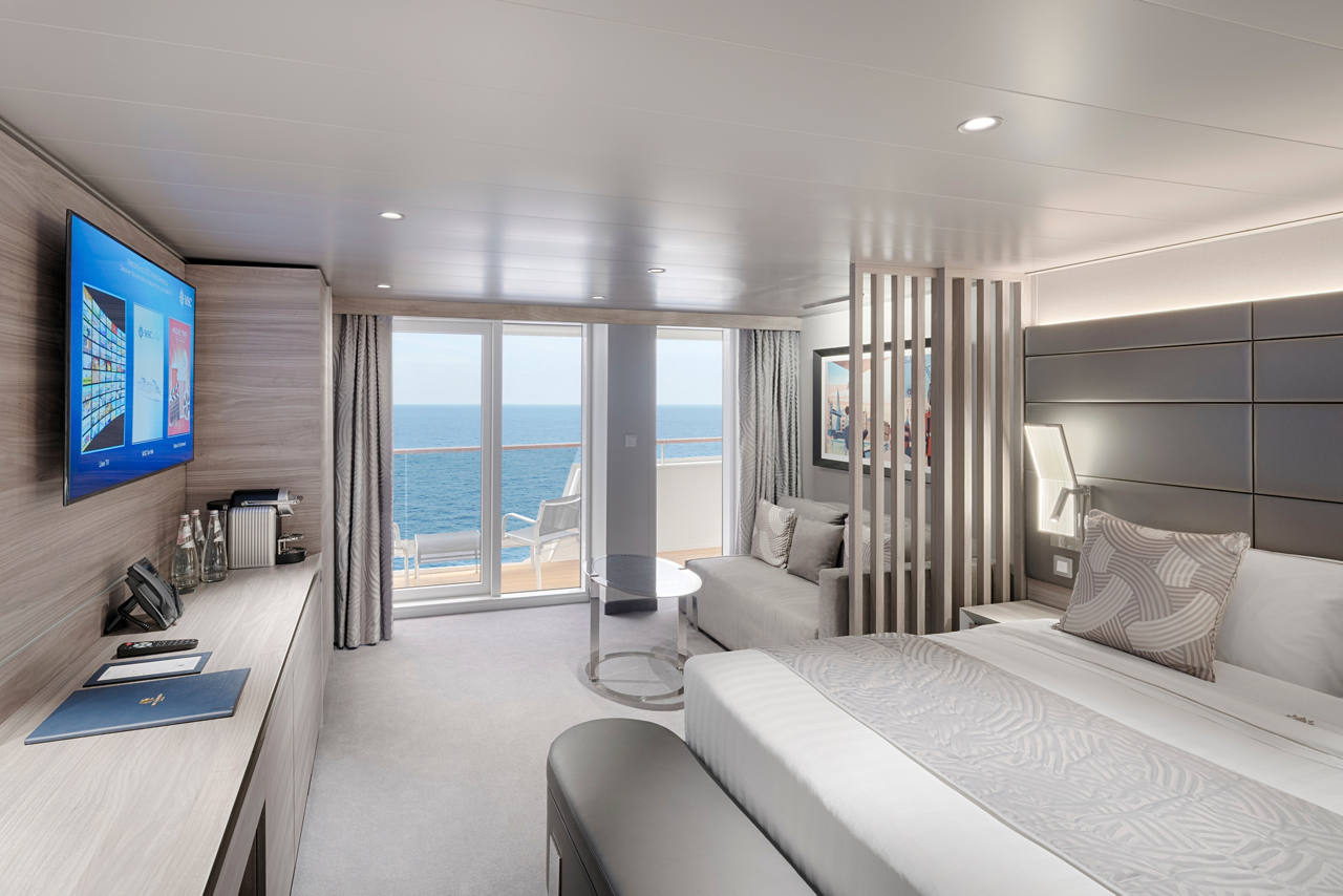 A stylish MSC Yacht Club Deluxe Suite with a double bed, a balcony, and stunning sea views | MSC Cruises