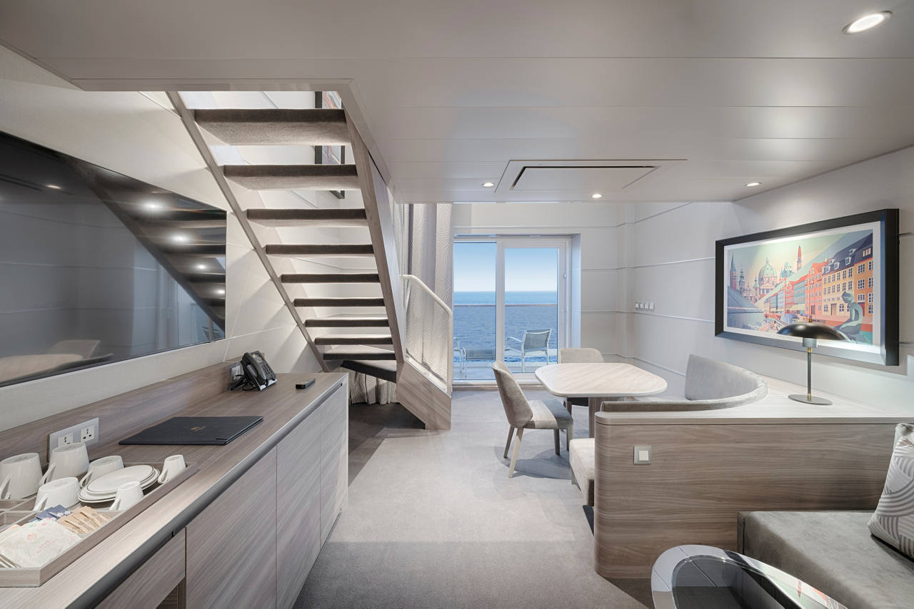 A stylish and modern MSC Yacht Club Deluxe Suite with a view of the sea and elegant furnishings | MSC Cruises