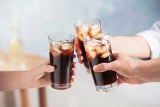 Two glasses of cola are clinking together in a celebratory toast | MSC Croisières