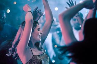 Friends joyfully dancing together under vibrant lights, celebrating life on board | MSC Cruises