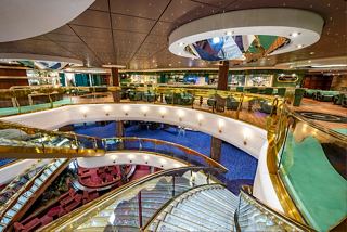 A welcoming lounge area on MSC Splendida featuring colourful furnishings, a bar counter, and comfortable seating | MSC Cruises