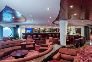 A stylish lounge area on MSC Splendida featuring comfortable seating and a bar counter for socialising | MSC Cruises