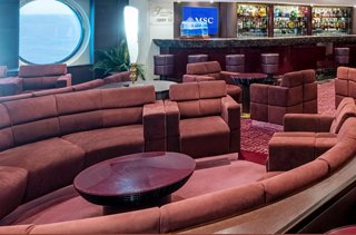 A stylish lounge area on MSC Splendida featuring comfortable seating and a bar counter for socialising | MSC Cruises