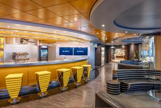 A vibrant bar area on MSC Splendida featuring seating, a counter, and a warm atmosphere for relaxation and socialising | MSC Cruises