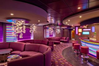 A vibrant lounge area with comfortable seating, a bar counter, and soft lighting | MSC Cruises