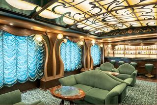 A stylish lounge area on MSC Splendida featuring comfortable seating and vibrant blue curtains | MSC Cruises