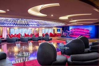 A vibrant lounge area on MSC Splendida featuring comfortable seating, a stage, and a lively atmosphere for entertainment | MSC Cruises