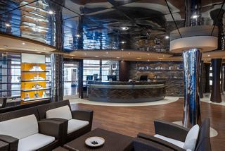 A stylish reception area of the MSC Aurea Spa featuring comfortable seating and a welcoming desk counter | MSC Cruises