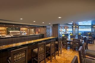 A stylish bar counter with seating, inviting guests to enjoy drinks and relax in a warm atmosphere onboard MSC Splendida | MSC Cruises
