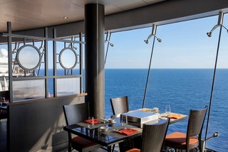A modern dining area with sea views featuring tables and chairs, perfect for enjoying a meal at Sea Pavilion | MSC Cruises