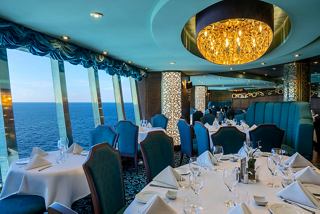 A beautifully arranged dining area in the Villa Verde Restaurant with ocean views and elegant decor | MSC Cruises
