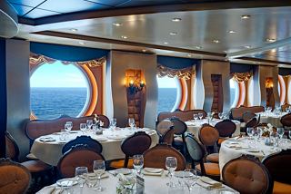 Elegant dining setup in La Reggia Restaurant with ocean views and warm decor for a memorable culinary experience | MSC Cruises