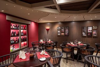 A warm and inviting dining area featuring tables and chairs ready for guests at the Butcher's Cut restaurant | MSC Cruises