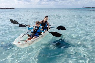 A mother and son enjoy kayaking together in the clear waters of Ocean Cay, surrounded by the beauty of the Caribbean | MSC Cruises