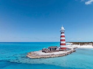 Eine ruhige Luftaufnahme eines Leuchtturms auf Ocean Cay, umgeben von klarem blauen Wasser und Sandstränden | MSC Cruises